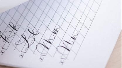 Handwritten notes on a lined notebook page with a pen and paper in the background.